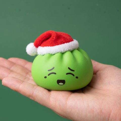 Dumpling Squishy Jultomtemössa Grön i handen, verklig storlek